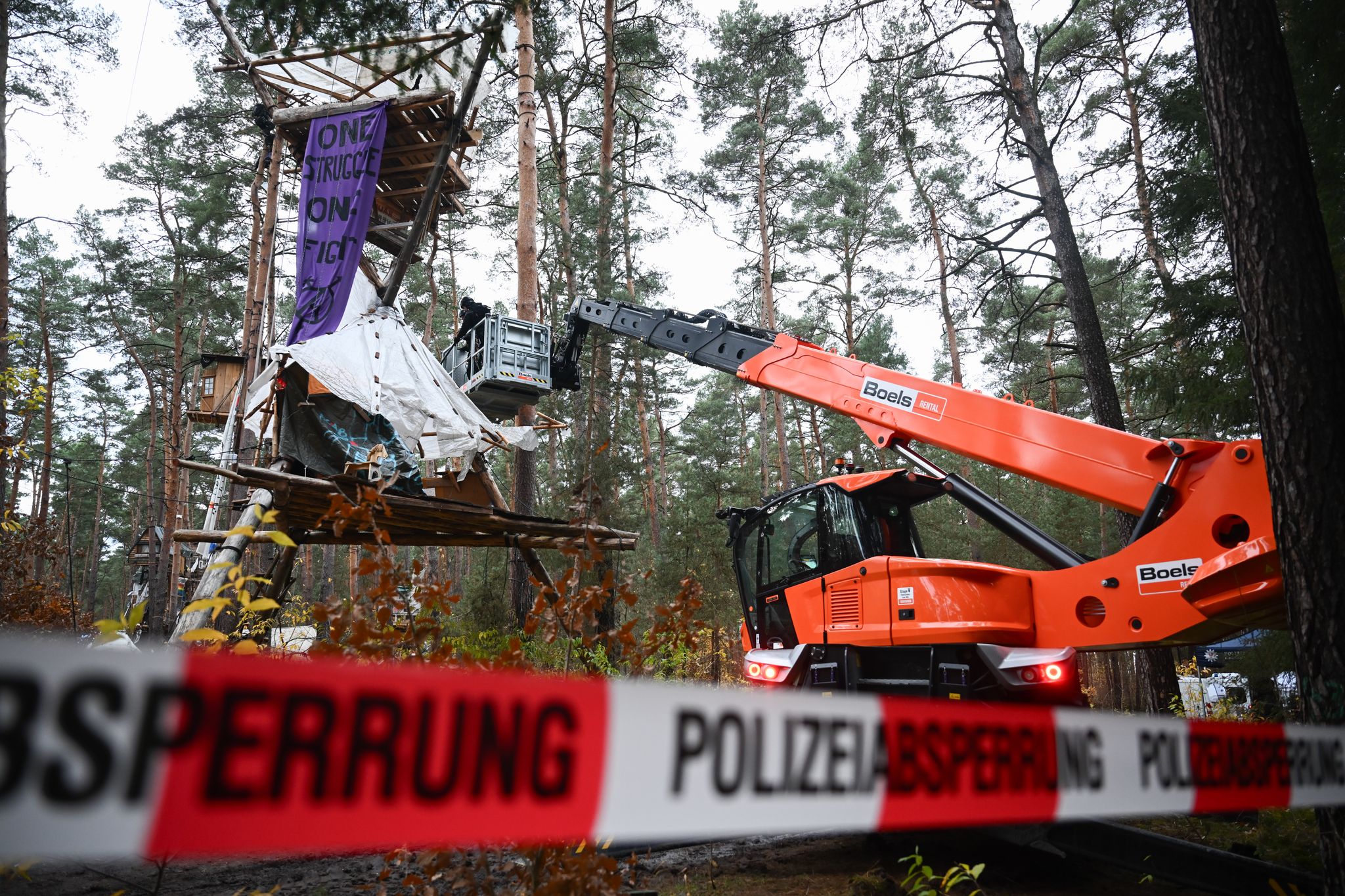 Mit Hilfe einer Hebebühne kommen die Polizeikräfte an die Baumhäuser im aufgelösten Tesla-Protestcamp heran.