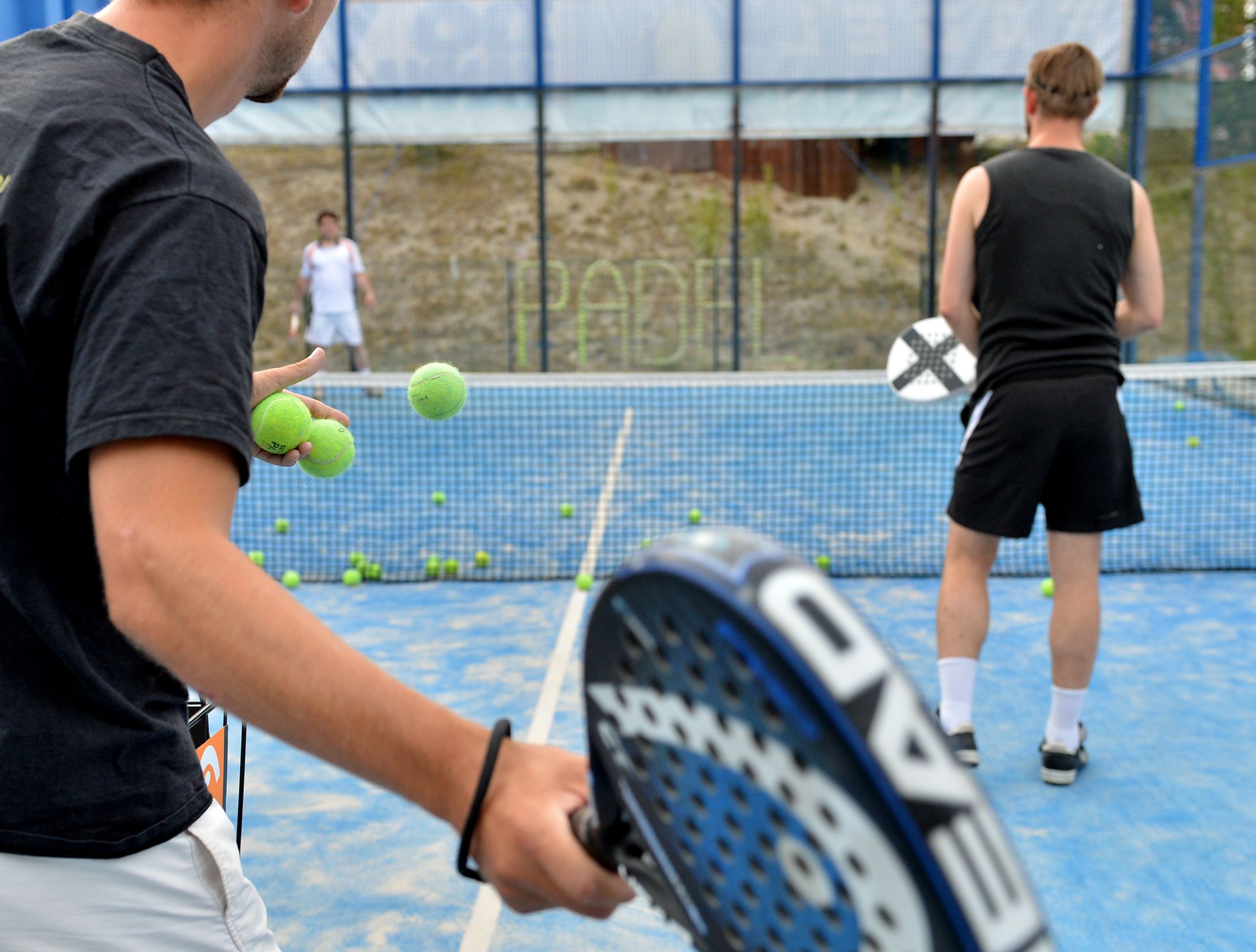 Mischung aus Tennis und Squash: Padel wird in einer Art Käfig gespielt, dessen Wände aus Glas oder Drahtgitter bestehen.