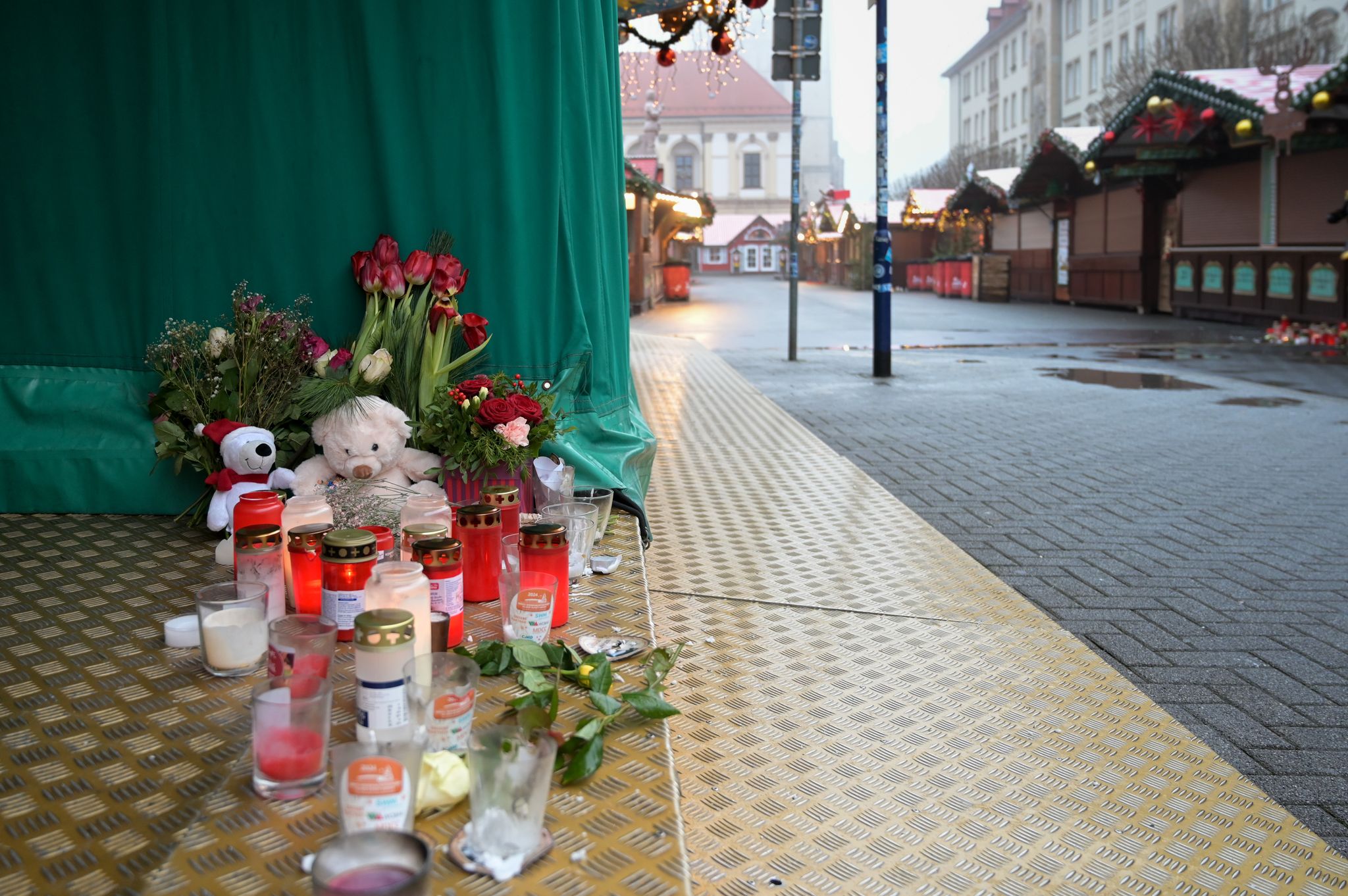 Menschen haben Blumen, Kerzen und Plüschtiere niedergelegt.