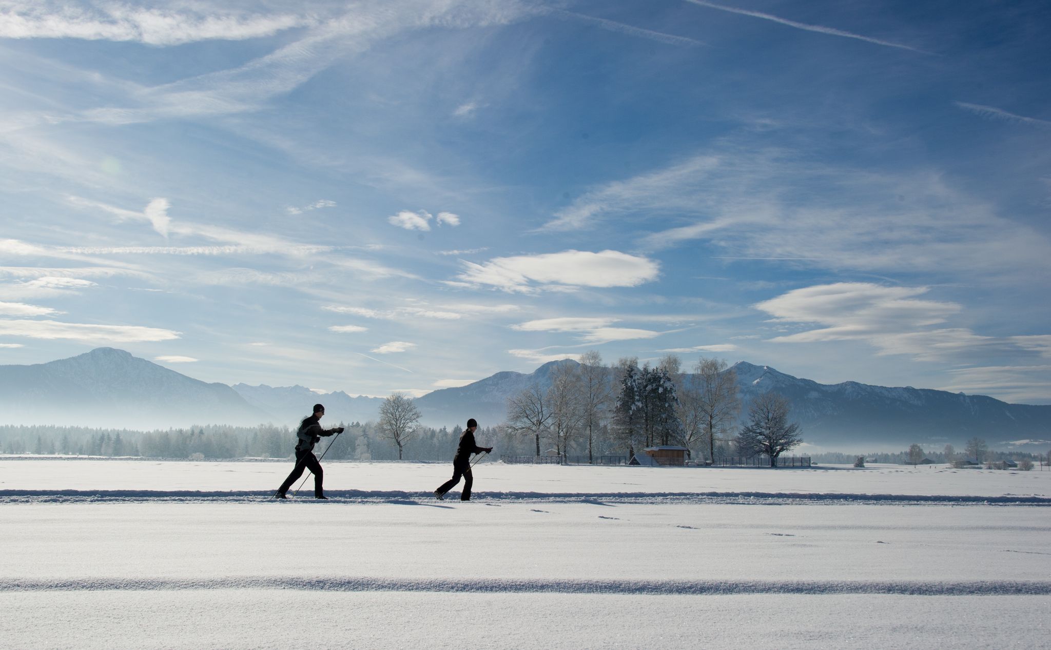 Bei der Klassik-Variante des Skilanglaufs gleitet man auf langen Skiern in zwei parallelen Spuren im Schnee.