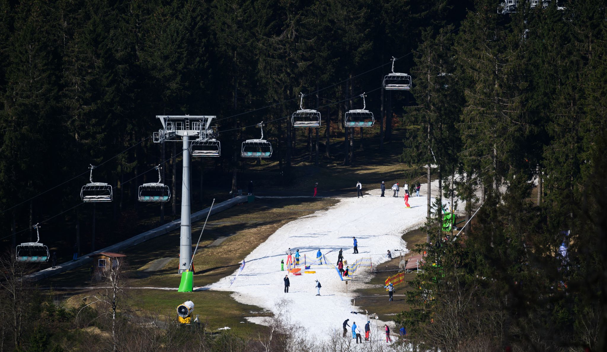 Der visualisierte Alptraum jedes Skiurlaubers: Schneemangel und damit nur schmale weiße Pistenteppiche auf braun-grünen Hängen.