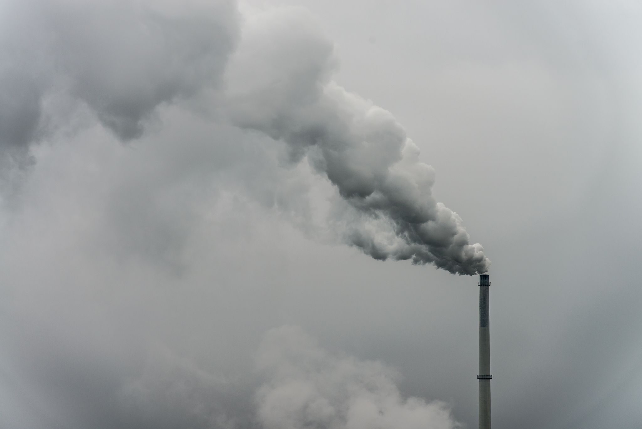 Rauch steigt aus dem Schornstein einer Fabrik. Das Wirtschaftswachstum in Deutschland wird nach Einschätzung vieler Fachleute auch in den kommenden Jahren nahezu stagnieren. (Symbolbild)