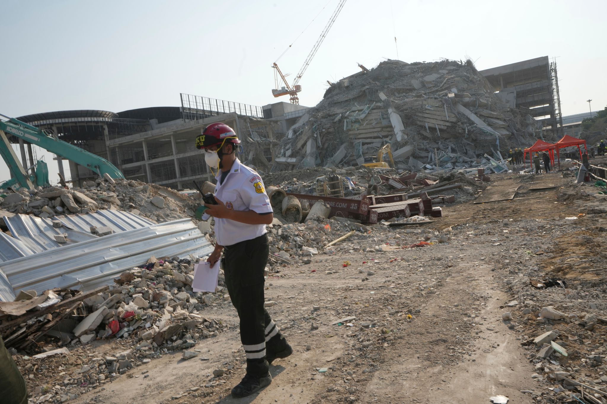 Ein Rettungshelfer geht an der Stelle vorbei, an der ein im Bau befindliches Hochhaus nach einem Erdbeben der Stärke 7,7 zusammengebrochen ist. Ein starkes Beben mit Epizentrum im Nachbarland Myanmar hat die Region in Südostasien erschüttert.