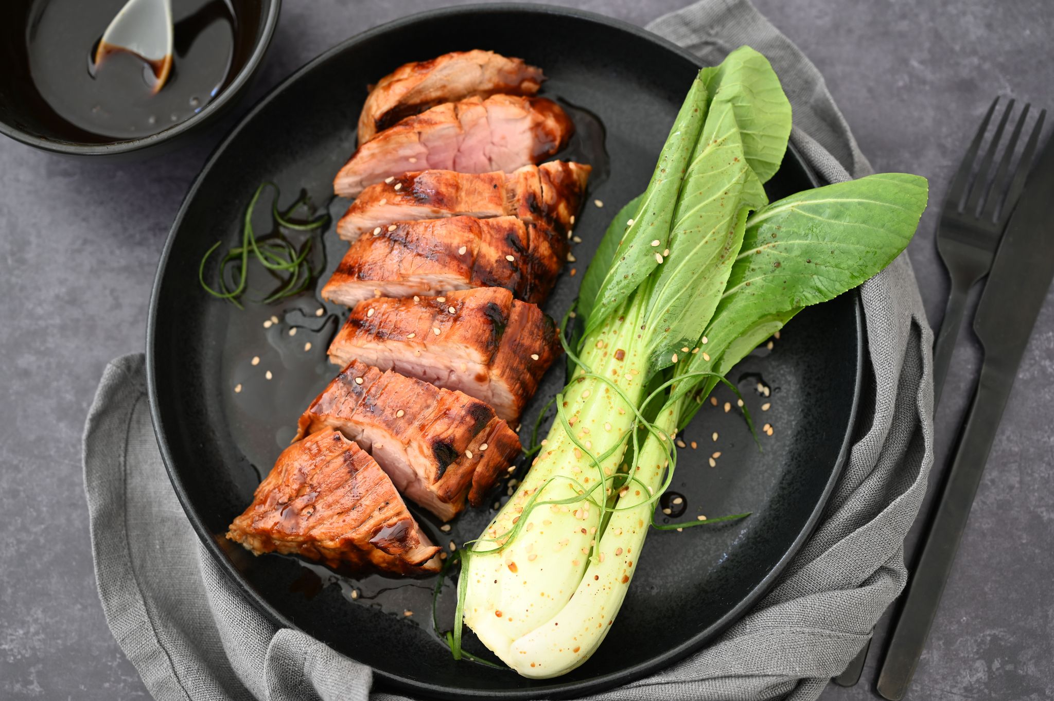 Hoisin-Sauce gibt dem Schweinefilet Würze und eine Karamellnote. Dazu wird Pak Choi serviert.