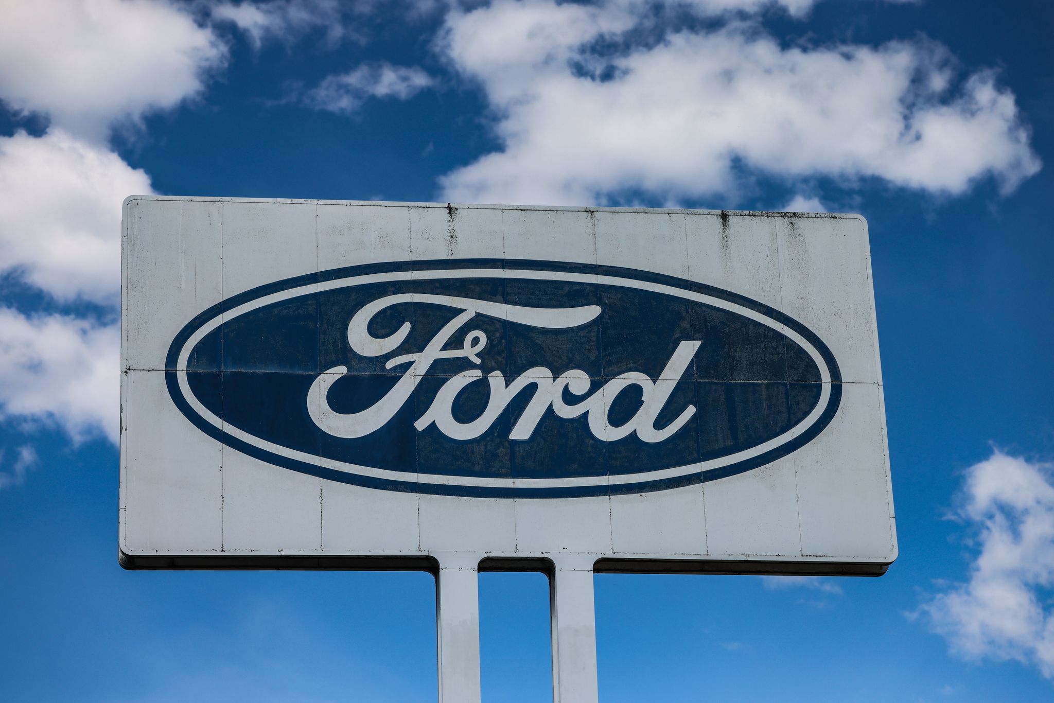 Ein Logo steht vor dem Ford Werk bei gutem Wetter - wirtschaftlich gesehen sind die Perspektiven des Ford-Autogeschäfts in Europa düster.