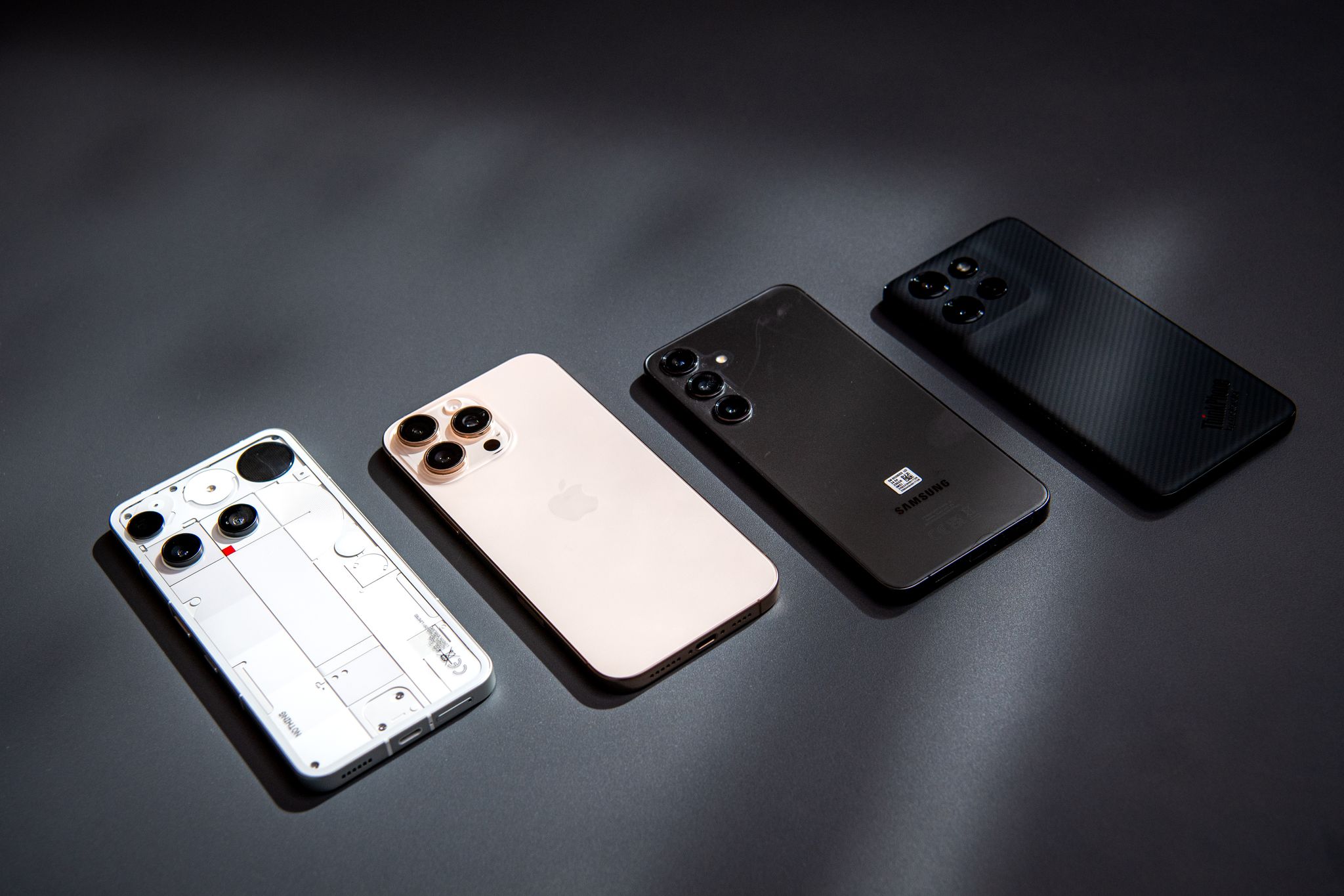 Schon anders als die anderen: Das Nothing Phone 3, neben iPhone 16 Pro, Samsung Galaxy S24+ und Motorola Thinkphone (v.l.n.r.)