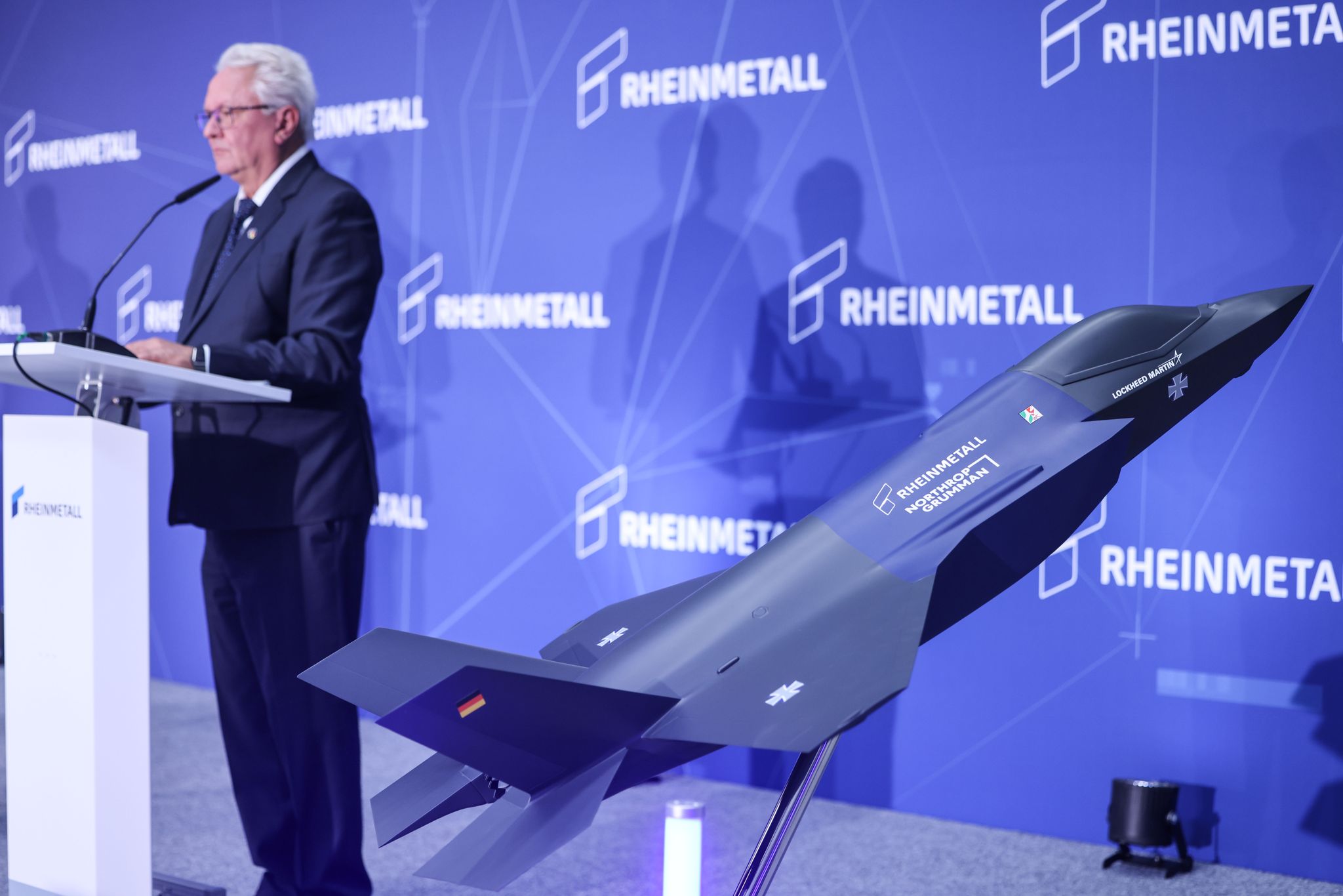 Ein Modell des F-35 auf der Bühne, auf der Konzernchef Papperger zu Mitarbeitern spricht.