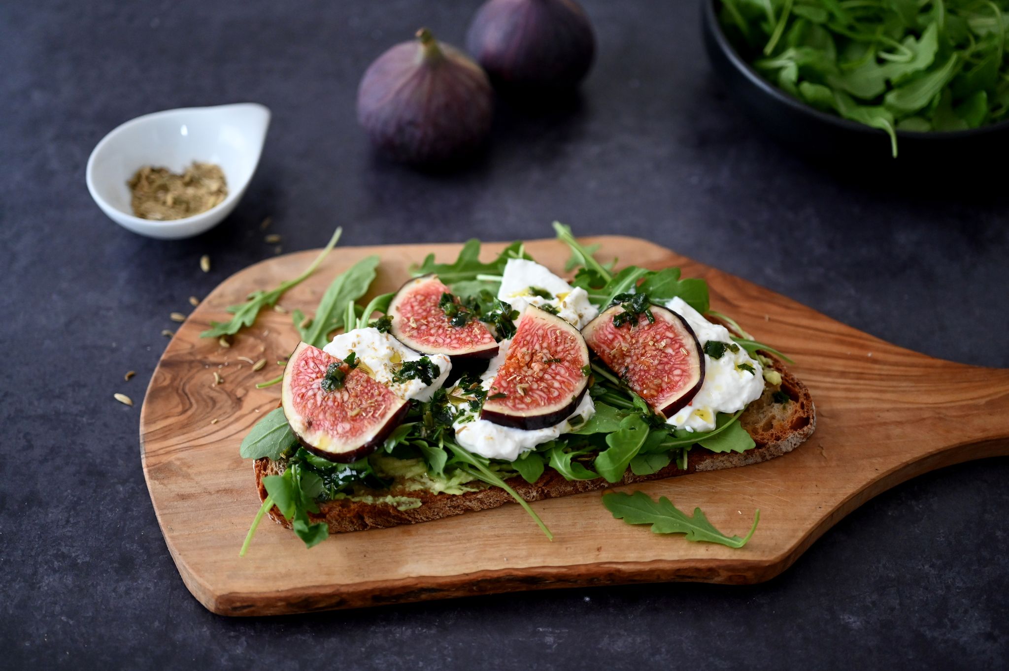 Das Butterbrot wird zunächst in der Pfanne knusprig angebraten. Belegt mit Rucola, Burrata und Feigen wird es zum Bauernbrot.