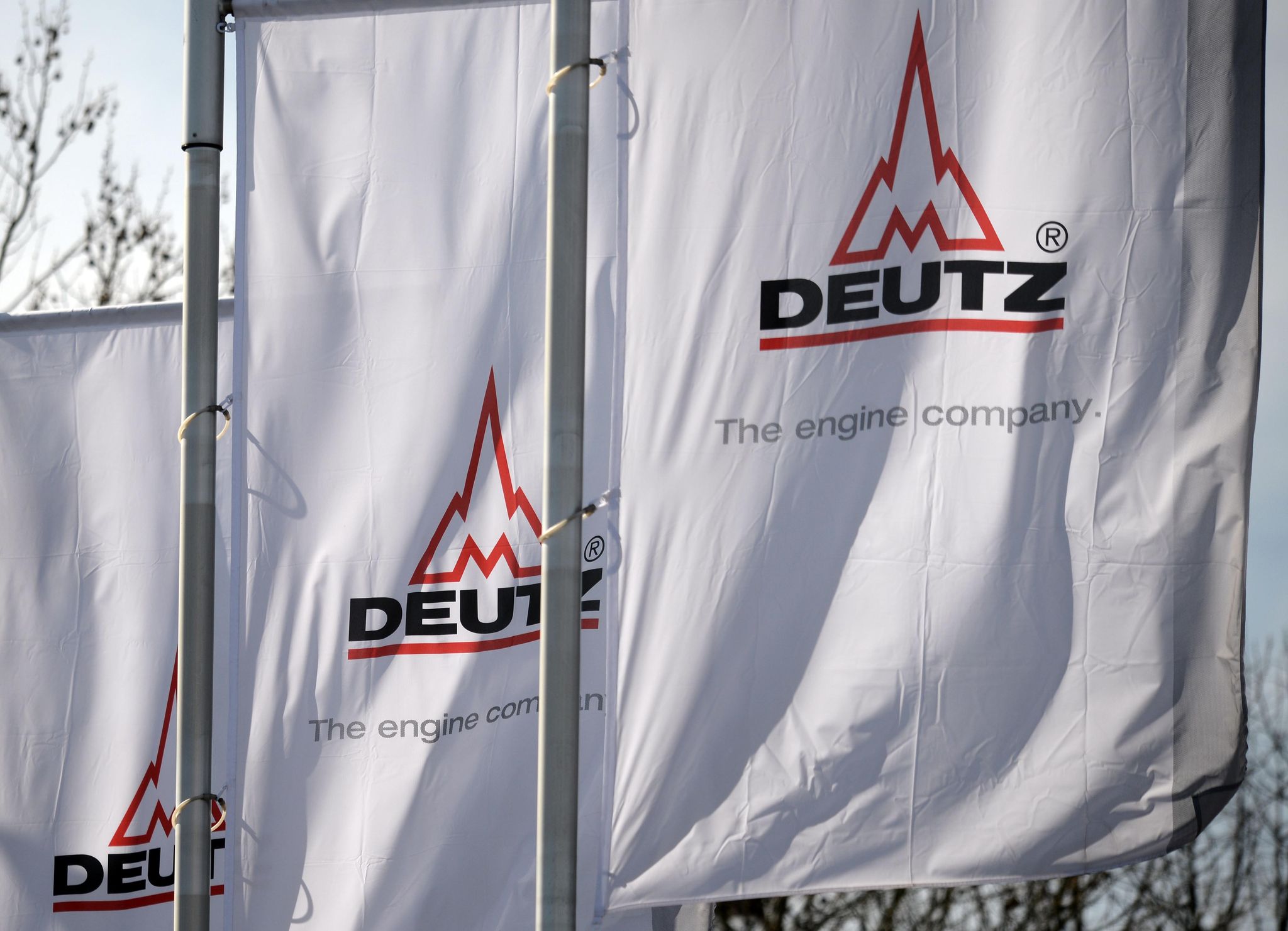 Deutz-Fahnen im Wind - über ihnen am Himmel fliegen bald vielleicht Drohnen, die Komponenten aus firmeneigener Produktion enthalten.