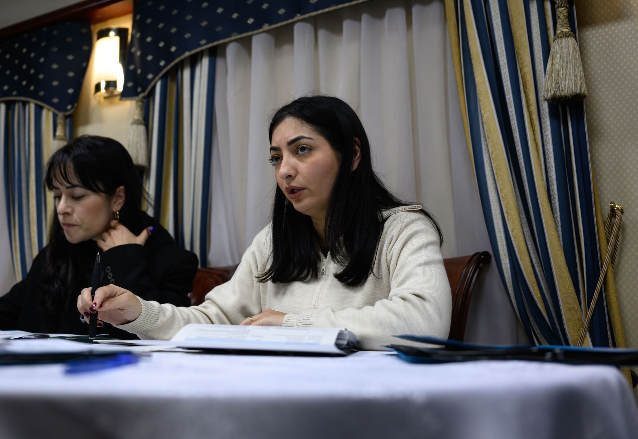 Reem Alabali Radovan (SPD, r), Bundesministerin für wirtschaftliche Zusammenarbeit und Entwicklung, und Pressesprecherin Aline Abboud besprechen im Zug nach Kiew das Reiseprogramm.