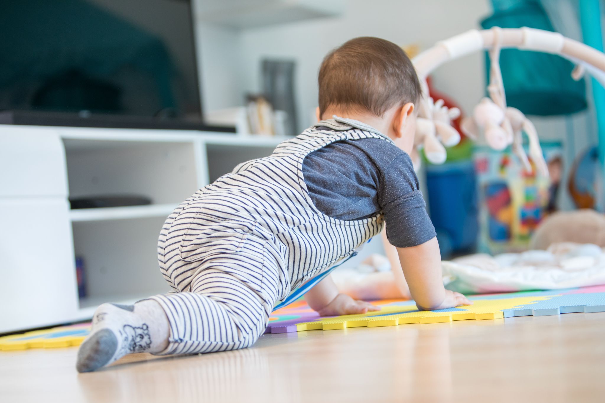 Krabbeln und entdecken: Häufiges Staubsaugen und feuchtes Wischen hilft, Babys vor im Hausstaub lauernden Schadstoffen zu schützen.