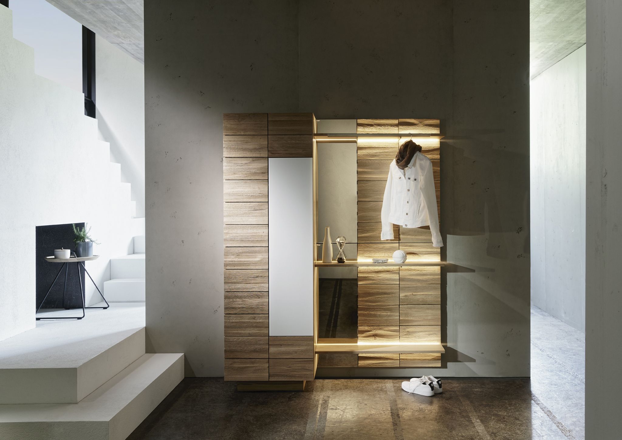 Ein Schrank mit Spiegel und Beleuchtung im Flur sorgt für Stauraum und ist praktisch, um kurz einen Blick aufs Outfit zu werfen.