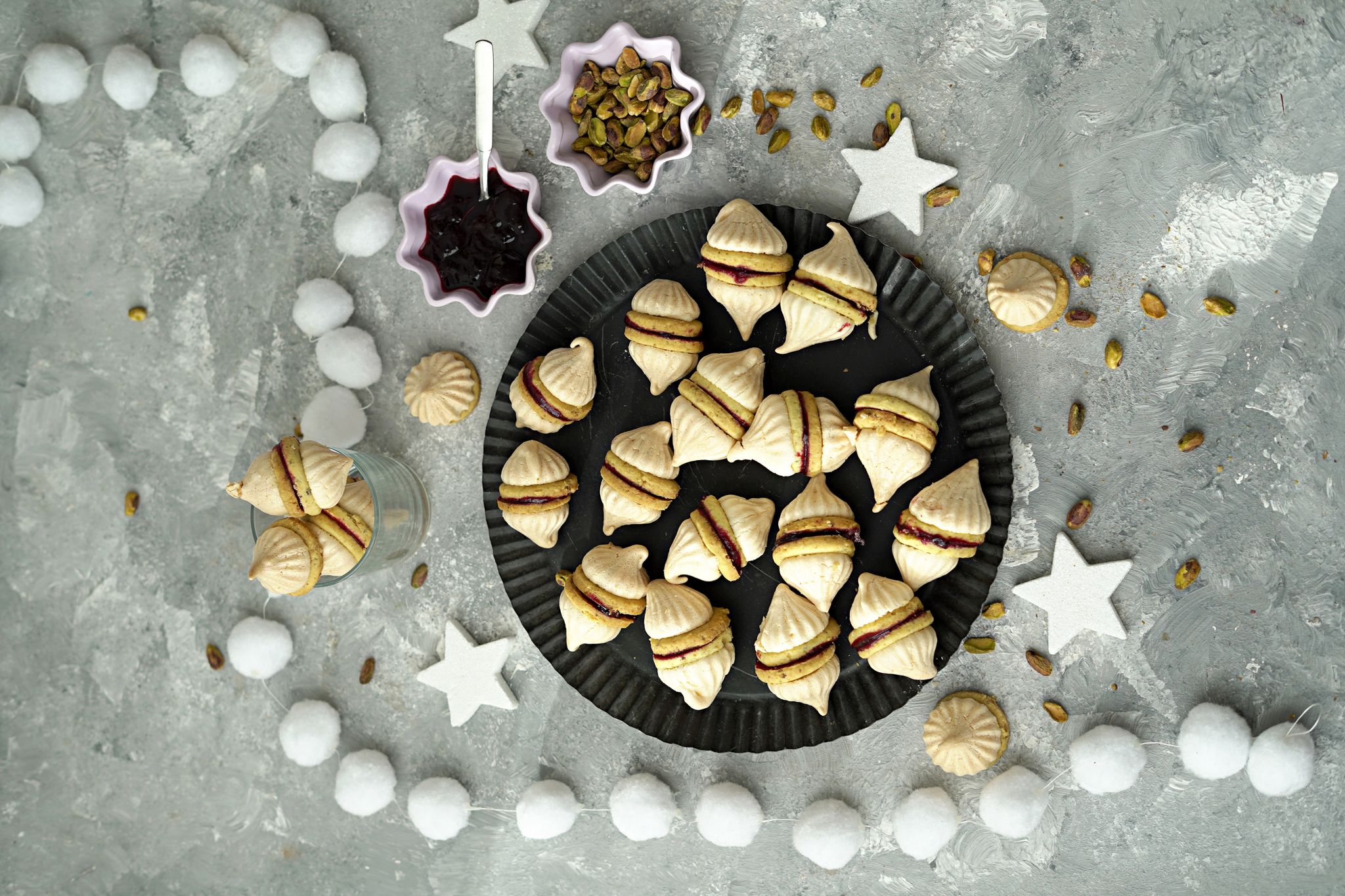 Durch die Geleefüllung werden zwei Vanillekipferl miteinander verbunden. Dann bekommt der Doppel-Keks auch noch zwei Zipfelmützchen in Form von Baiserhauben.