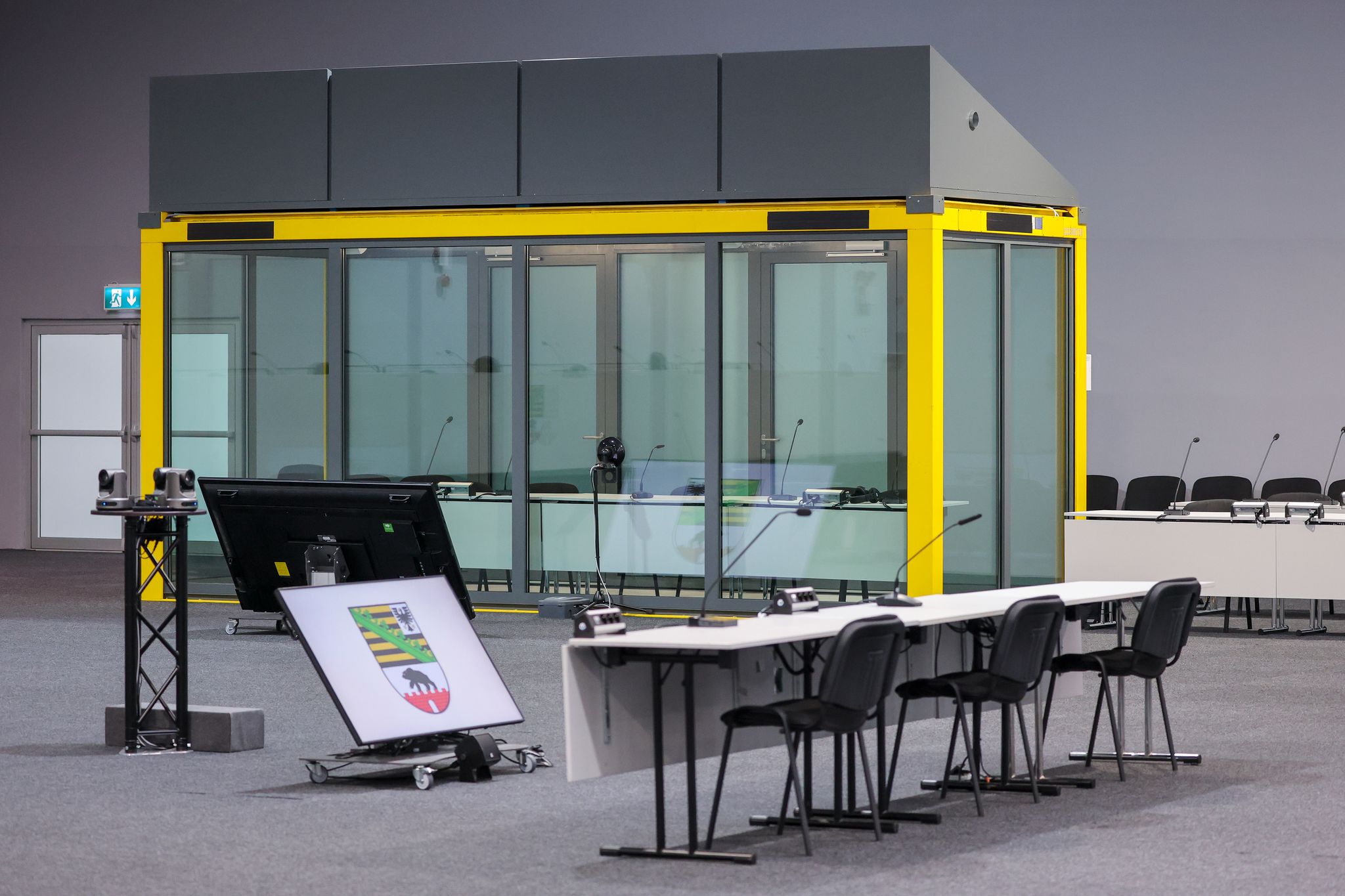 Ein Blick in den Gerichtssaal auf den Platz für die Zeugen und die Glaskabine, in der der Angeklagte während der Verhandlungen sitzt. (Archivbild)