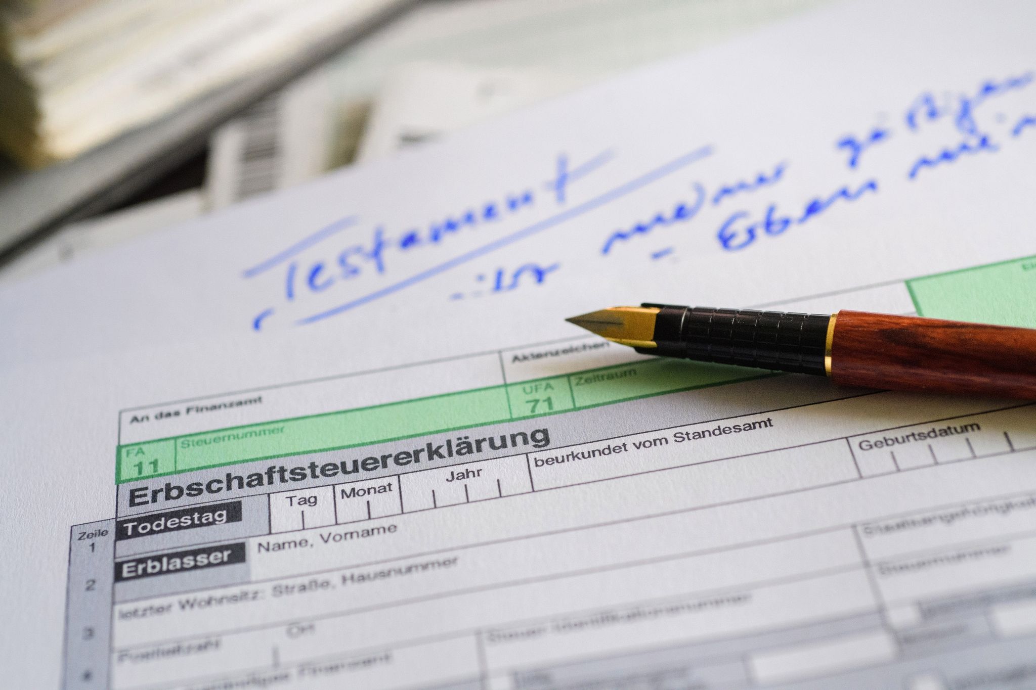 Ein Formular für die Erbschaftsteuererklärung sowie Stift und Testament liegen auf einem Tisch. (Symbolbild)