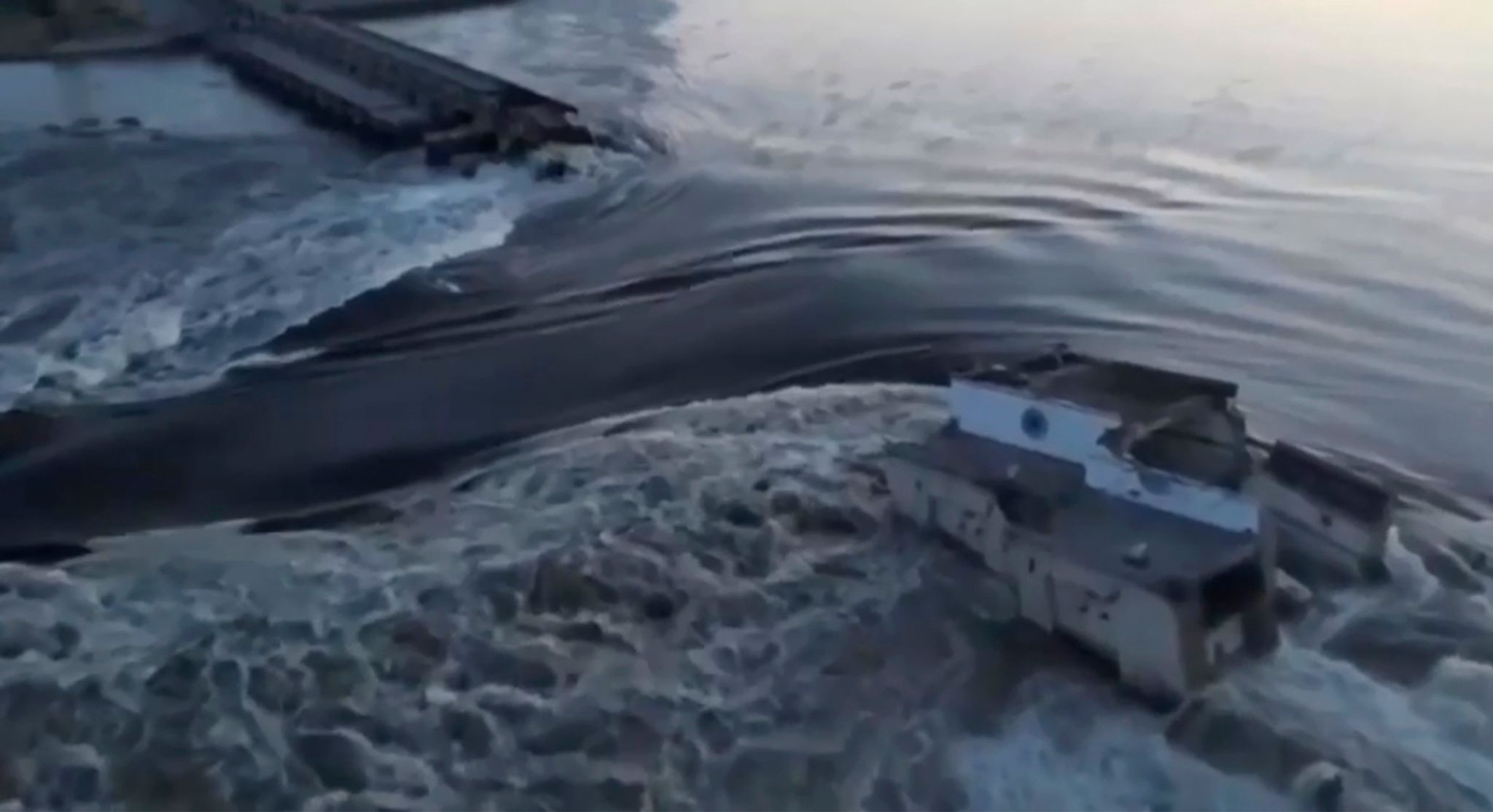 Das vom ukrainischen Präsidialamt über AP veröffentlichte Videostandbild zeigt Wasser, das durch einen Durchbruch im Kachowka-Staudamm fließt.
