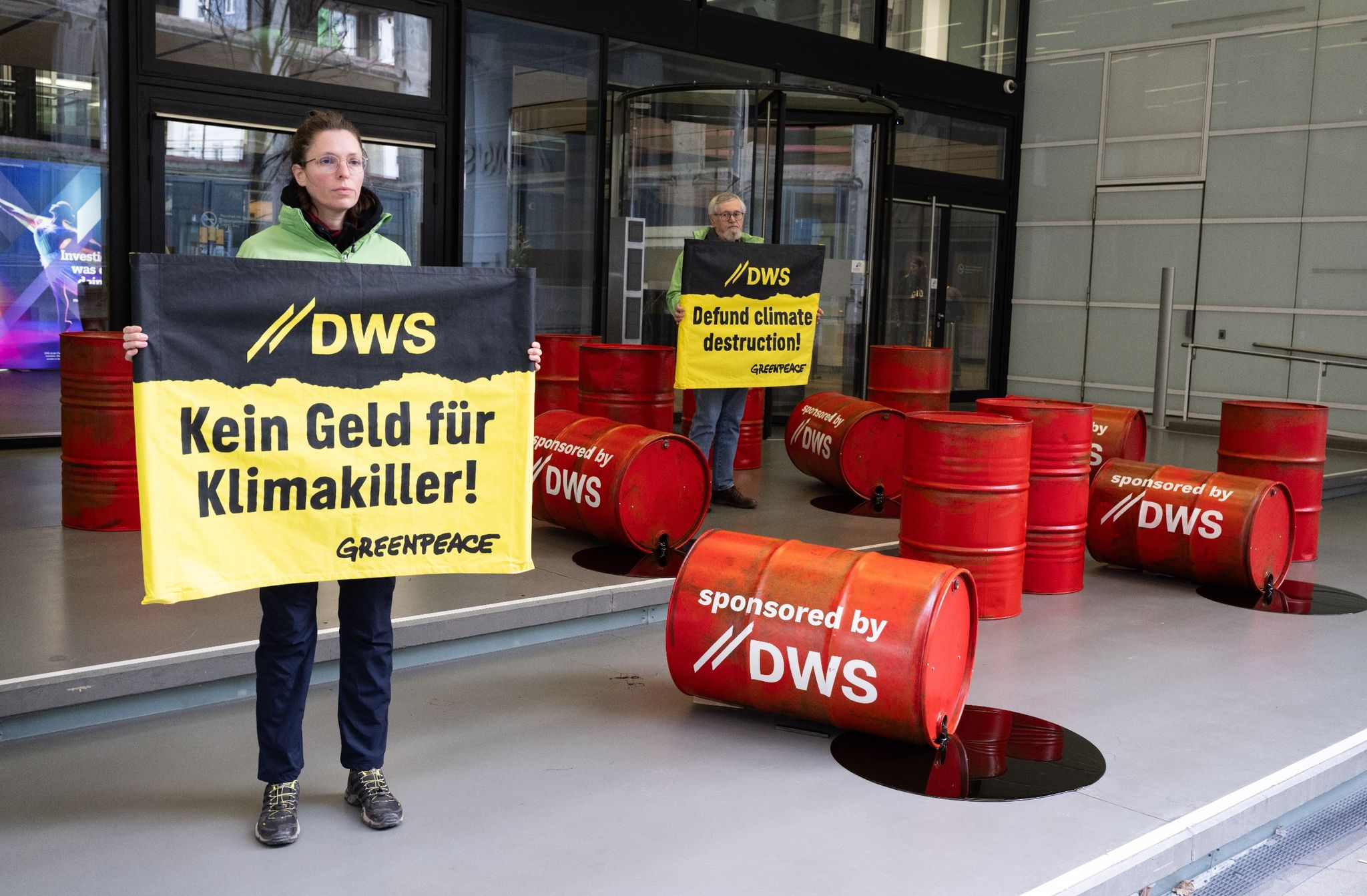 Mit roten Ölfässern protestieren Aktivisten von Greenpeace vor der Zentrale von DWS Investment in Frankfurt gegen die Investitionspolitik des Fonds.