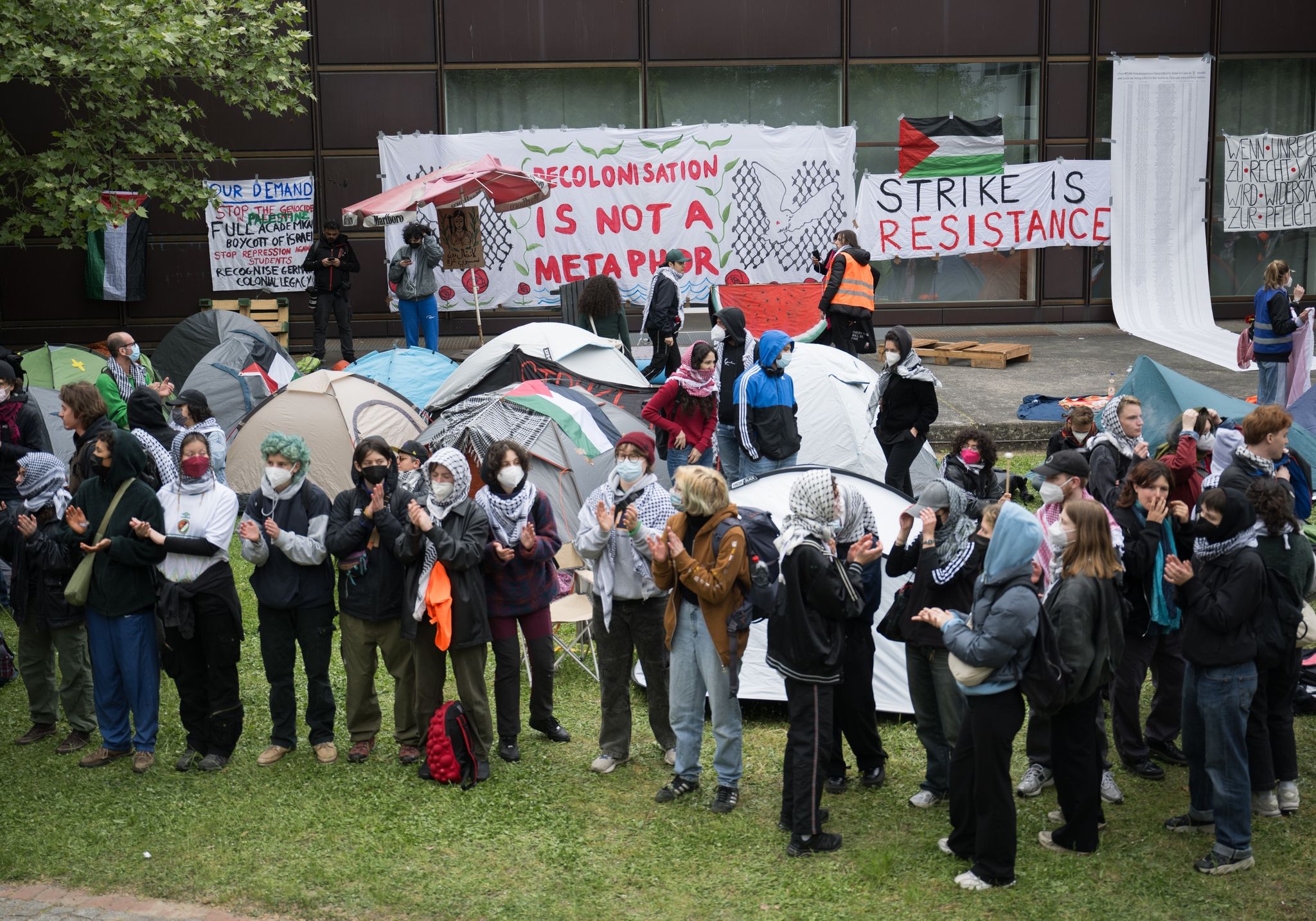 Teilnehmerinnen und Teilnehmer stehen während einer propalästinensischen Demonstration der Gruppe «Student Coalition Berlin» auf dem Theaterhof der Freien Universität Berlin.