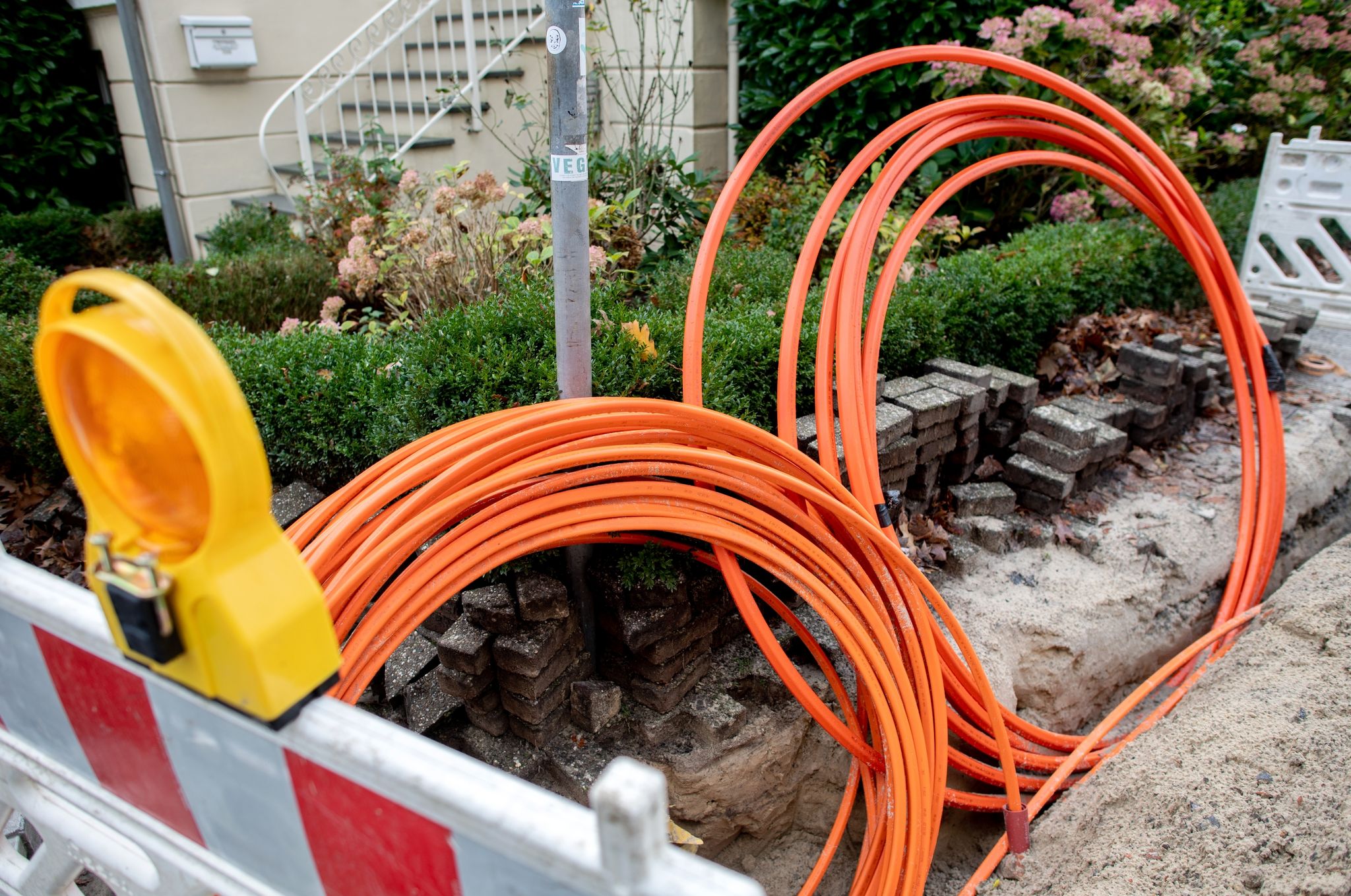 Leerrohre für neue Glasfaserkabel liegen auf einer Baustelle.