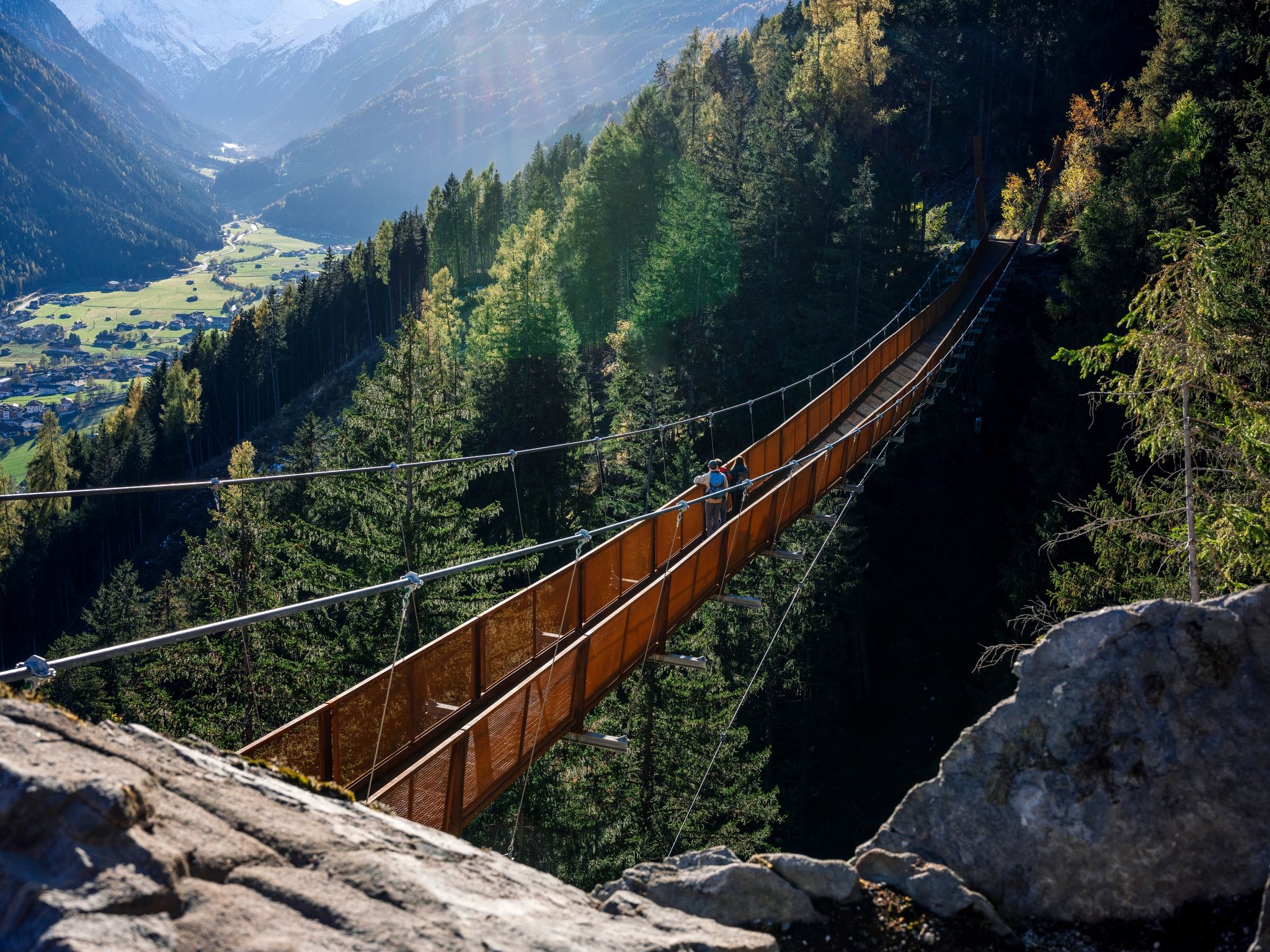 Wandern mit Aussicht: Die mehr als 100 Meter lange Hängebrücke im Stubaital führt an einem Berghang 46 Meter über den Boden und eröffnet einen Fernblick auf den Ort Neustift.