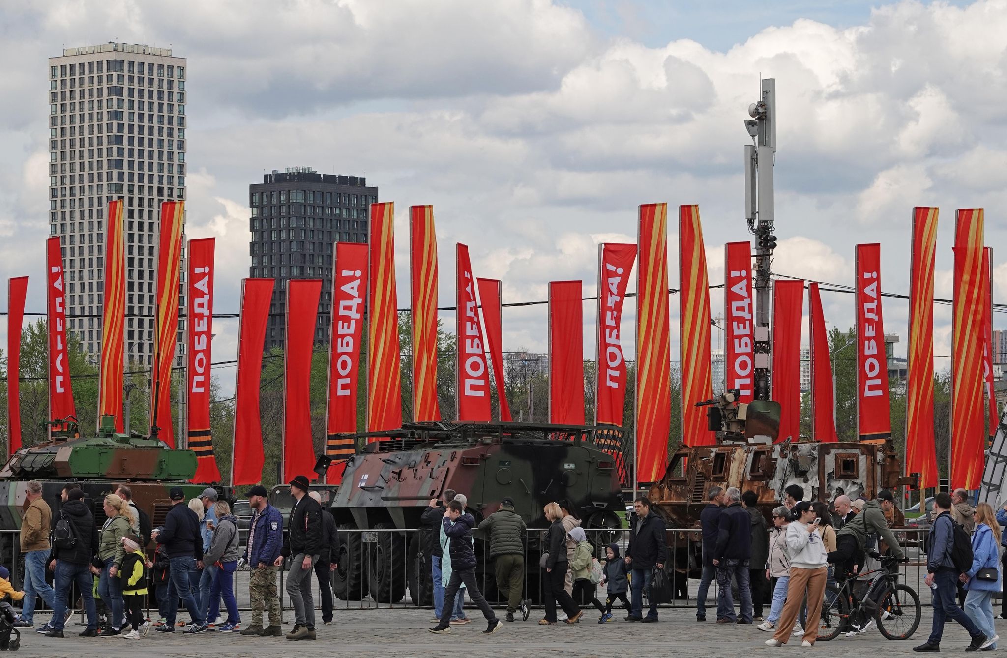 Menschen besichtigen eine Schau zu Kriegstrophäen im Park Pobedy (Park des Sieges) in Moskau. Gezeigt wird Militärtechnik aus verschiedenen westlichen Ländern und der Ukraine. Im Hintergrund zu sehen sind rote Fahnen mit der Aufschrift Pobeda! (auf Deutsch: Sieg).
