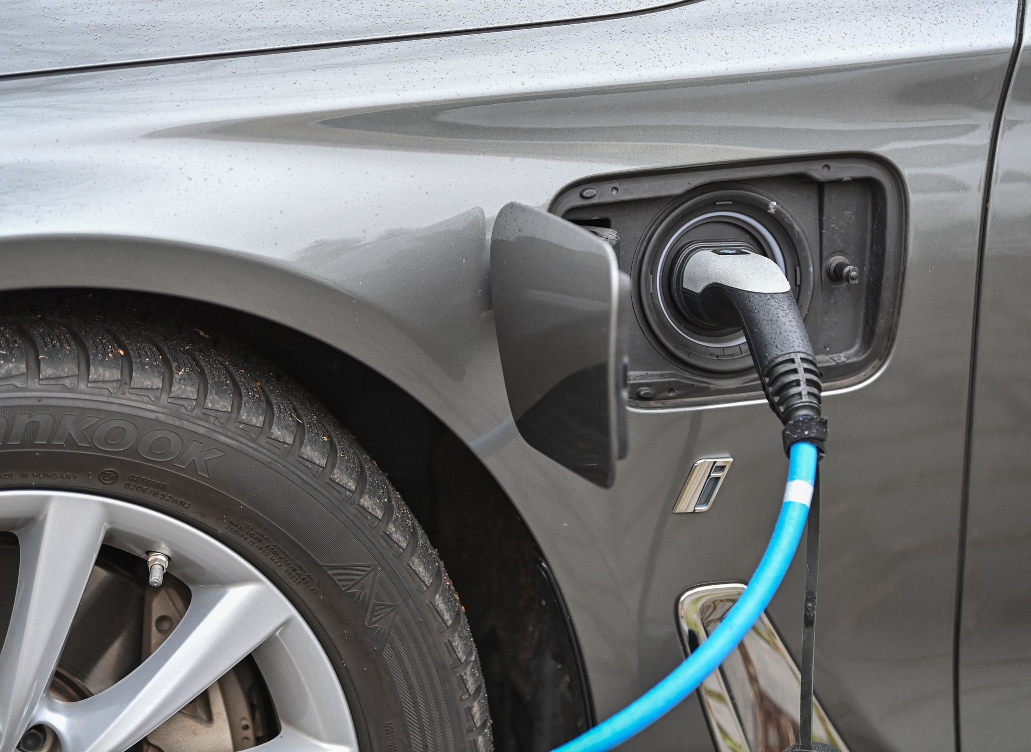 Ein Elektrofahrzeug der Marke BMW wird an einer Ladesäule aufgeladen.