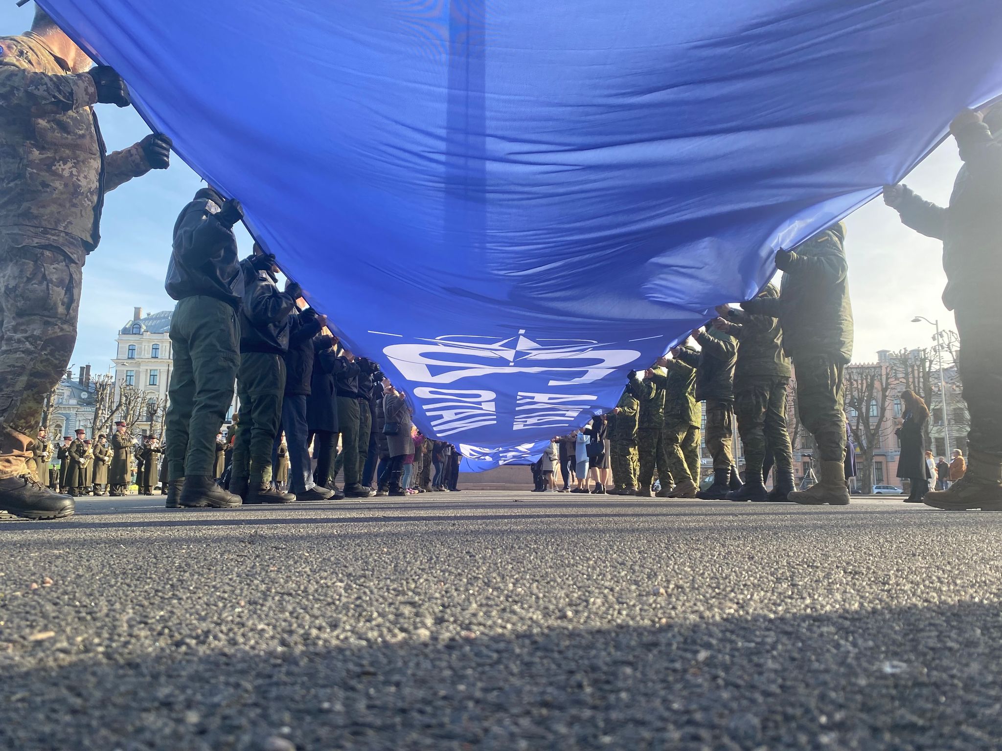 Ein riesige blaue Fahne mit der Aufschrift «Latvija Nato 20» wird vor dem Freiheitsdenkmal entrollt. Lettland feiert 20 Jahre Nato-Mitgliedschaft.