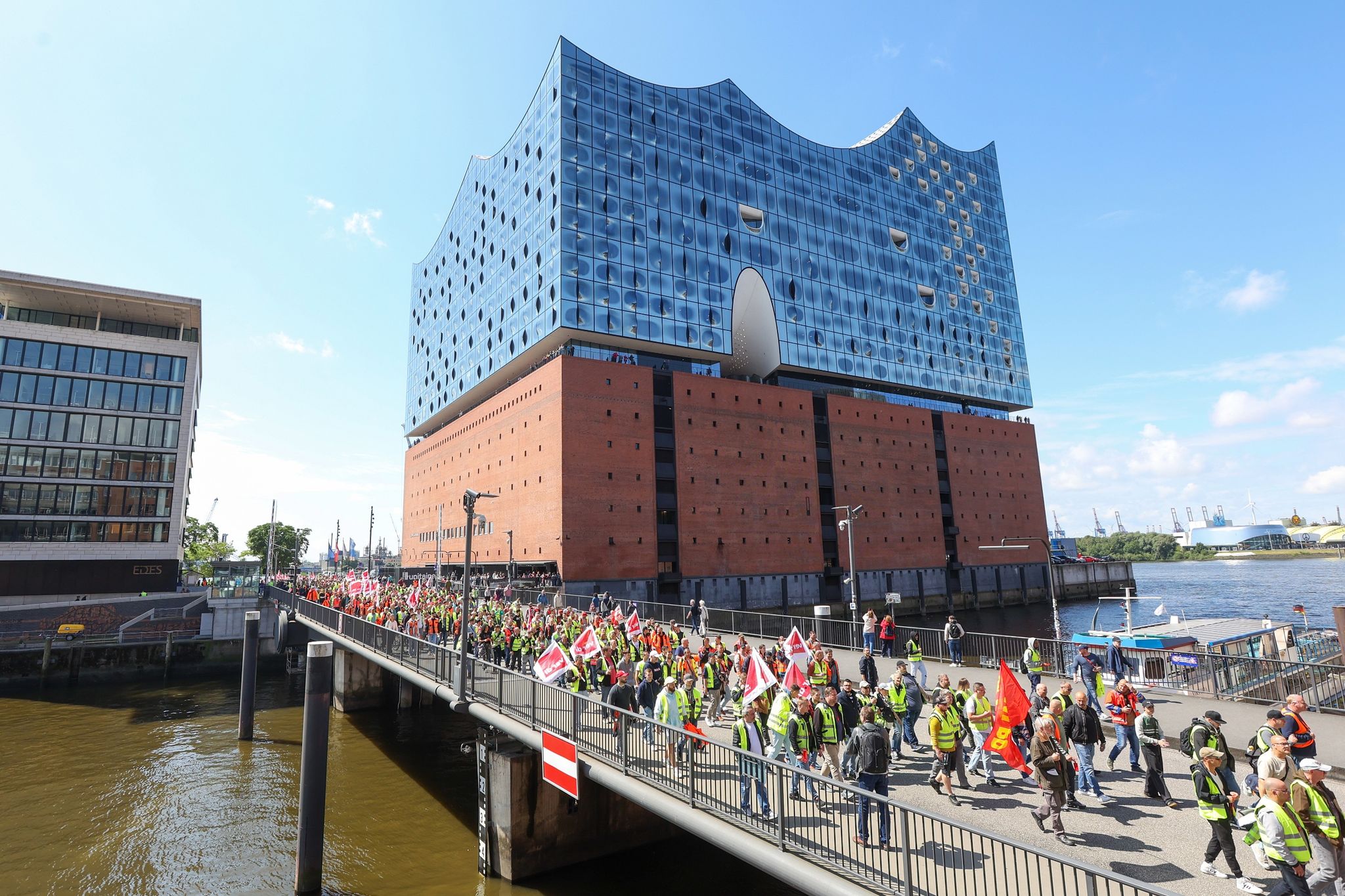 Streikende Hafenarbeiter ziehen bei einer Demonstration an der Hamburger Elbphilharmonie entlang.